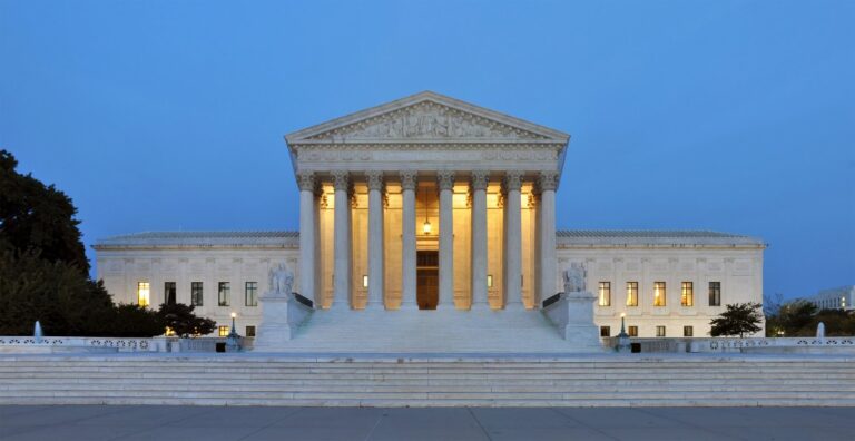 The front of the US Supreme Court building in Washington, DC, lit at dusk