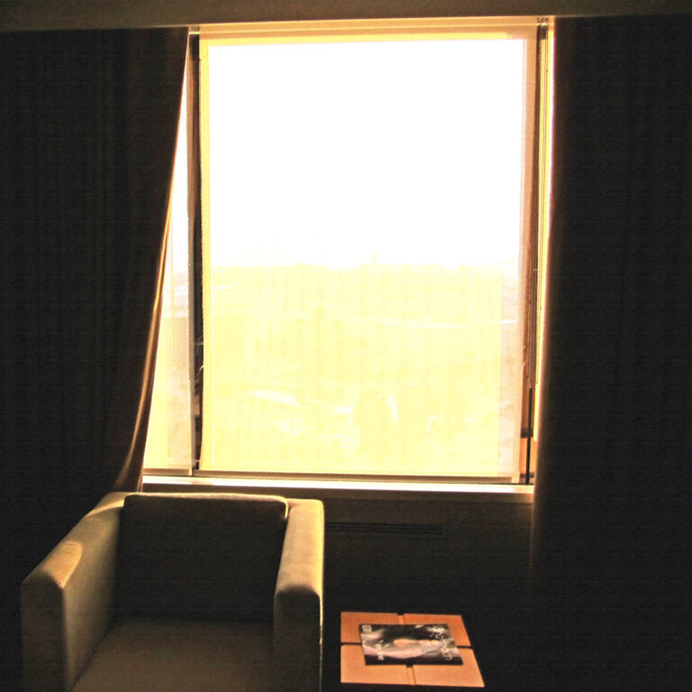 An empty armchair beside a bright window in a quiet room