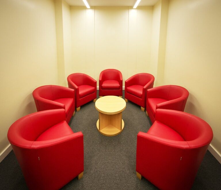 Empty red armchairs arranged in a circle