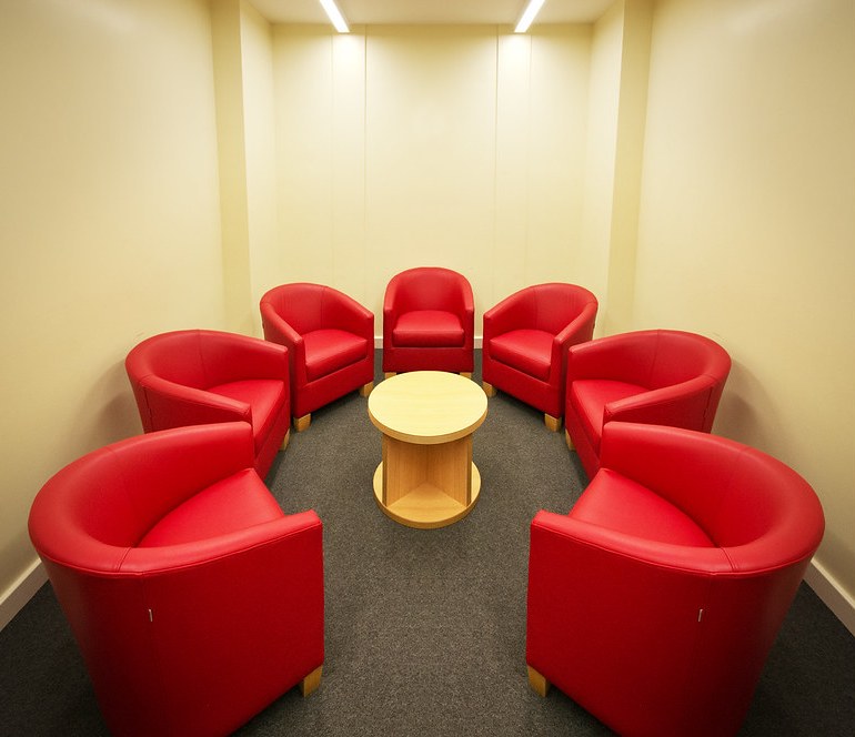 Empty red armchairs arranged in a circle
