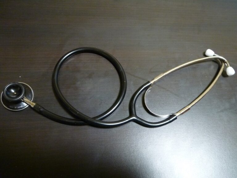 A stethoscope lying on a dark wooden table