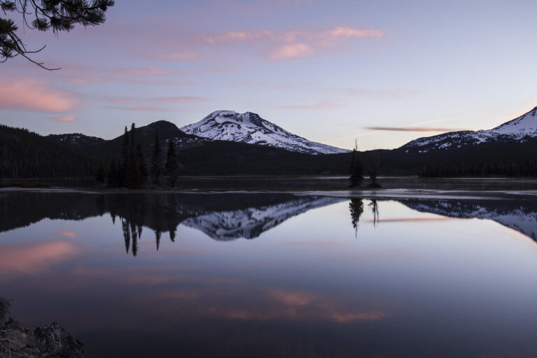 Sparks Lake in central Oregon at sunrise, with a snow-capped mountain reflected in still water