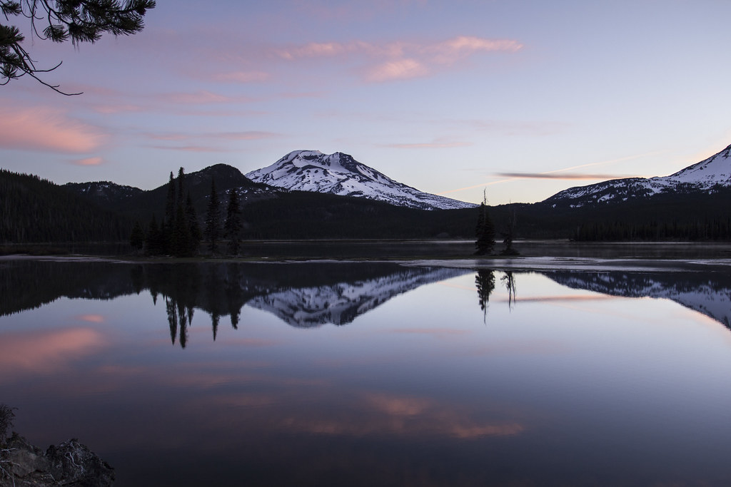 Sparks Lake in central Oregon at sunrise, with a snow-capped mountain reflected in still water