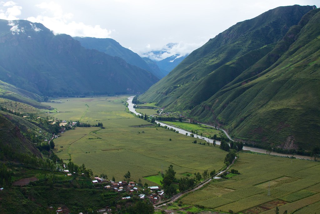A green river valley between steep mountains in the Sacred Valley of Peru
